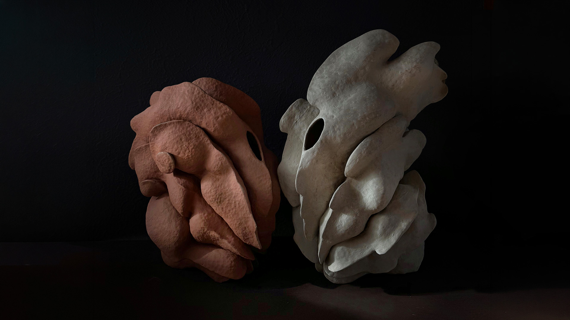 Two ceramic sculptures in a dark studio