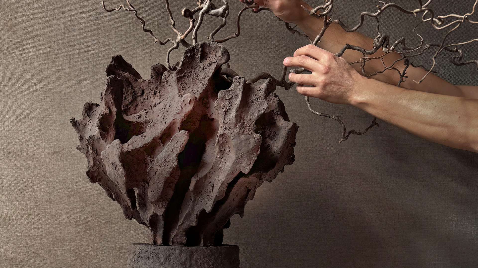 Ceramic sculpture with branch-like form and hands